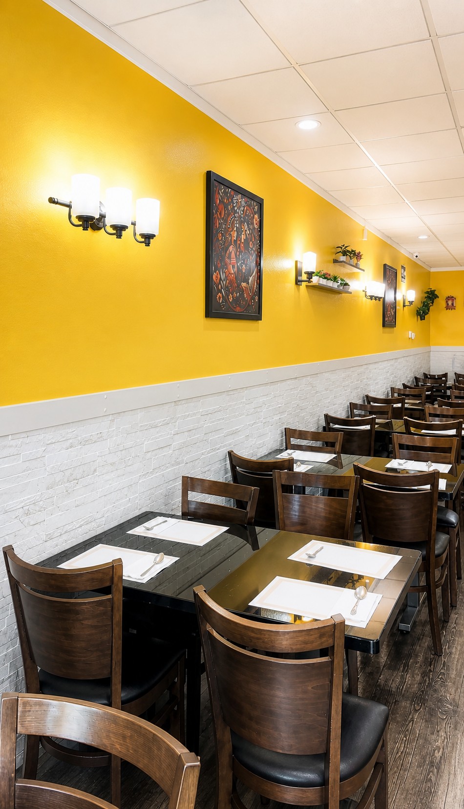 Rajbhog Thali restaurant interior with warm yellow walls and wooden chairs